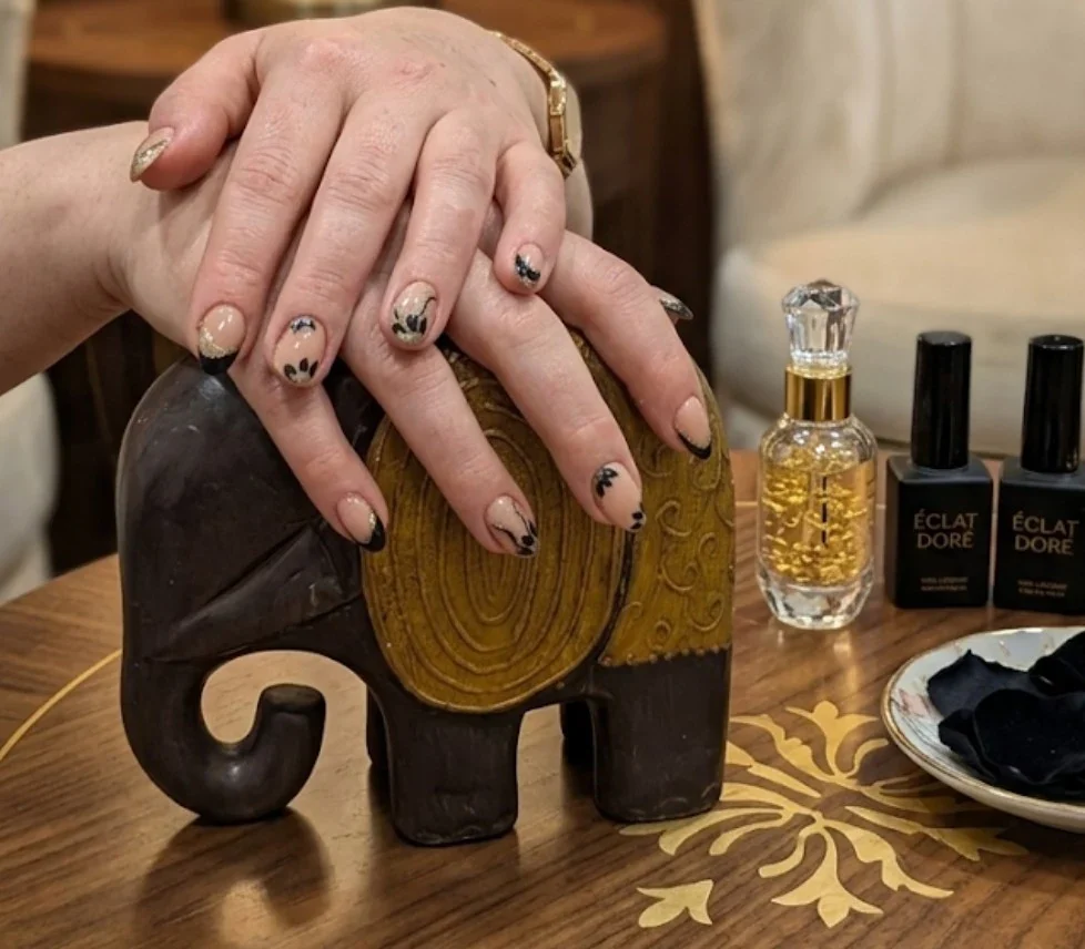 Nude-Nägel mit feiner Nailart neben einer Elefantenfigur