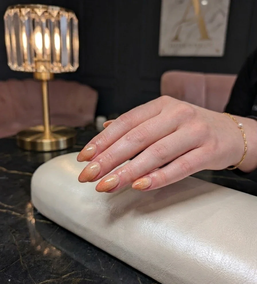 Nude-Nägel auf dem Polster im Studio, goldene Tischlampe